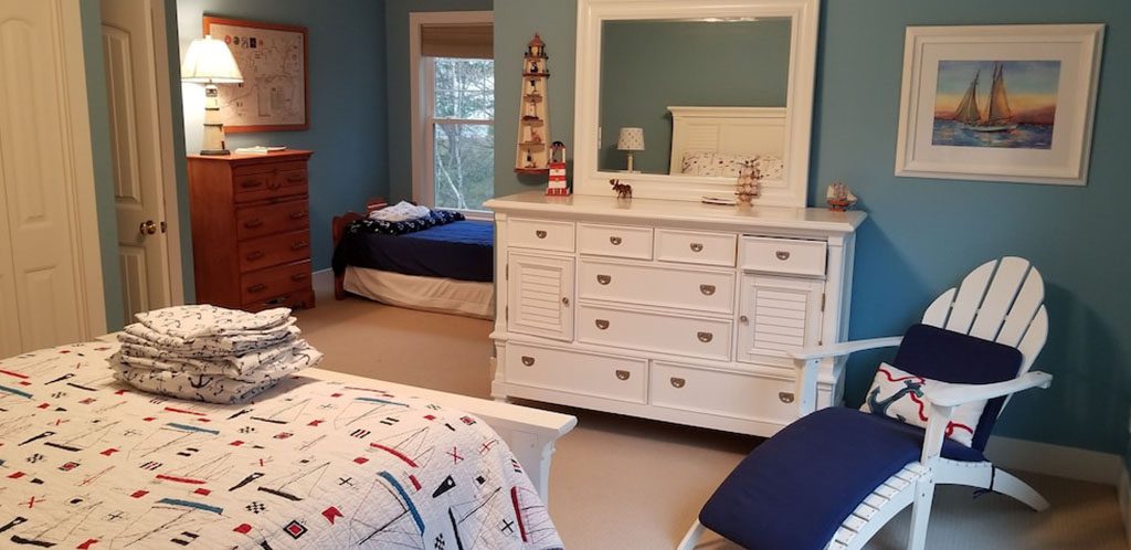 Bedroom With White and Blue Beds and White Furniture