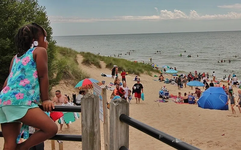 A young girl leaning over a railing in Tunnel Park Beach