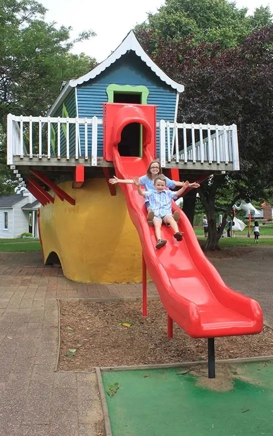 A young woman and a boy on a slide